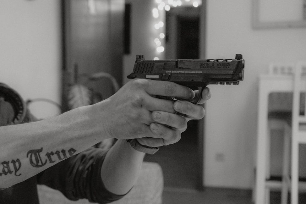 a-person-holding-a-gun-in-a-room-nzn2fkddtxq
